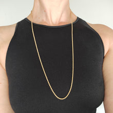 Load image into Gallery viewer, A yellow gold twisted rope chain with a bolt ring clasp, modelled by a woman wearing a black top
