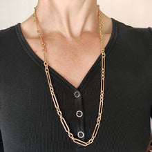 Load image into Gallery viewer, A gold trombone link chain necklace with a lobster claw clasp, modelled by a woman
