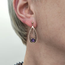 Load image into Gallery viewer, A pear shaped fan design drop earring with amethyst in yellow gold, modelled in an ear
