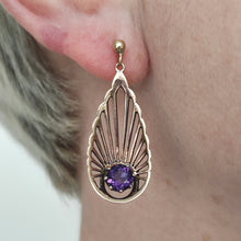 Load image into Gallery viewer, A pear shaped fan design drop earring with amethyst in yellow gold, modelled in an ear
