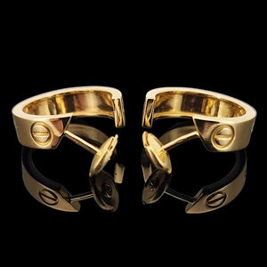Pair of gold Cartier hoop earrings on a black background