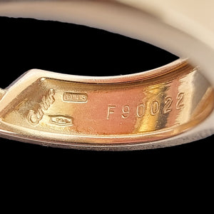 Close-up of a gold earring with visible Cartier branding and number 'F90022'
