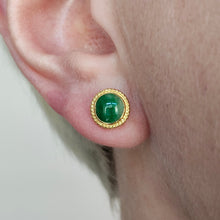 Load image into Gallery viewer, A round jade stud earring in yellow gold, modelled in an ear
