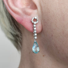 Load image into Gallery viewer, An aquamarine and diamond drop earring in white gold, modelled in an ear
