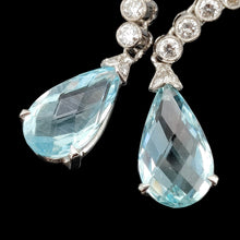 Load image into Gallery viewer, A pair of aquamarine and diamond drop earrings in white gold, on a black background
