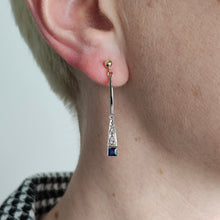 Load image into Gallery viewer, A sapphire and diamond long drop earring in yellow and white gold, modelled in an ear
