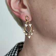Load image into Gallery viewer, A yellow gold open heart shaped drop earring with diamonds, modelled in an ear
