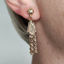 Load image into Gallery viewer, A yellow gold fancy engraved tassel drop earring, modelled in an ear
