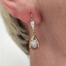 Load image into Gallery viewer, A yellow and white gold diamond set drop earring, modelled in an ear
