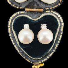 Load image into Gallery viewer, A pair of white pearl and round diamond stud earrings in white gold, in a black heart-shaped jewellery box
