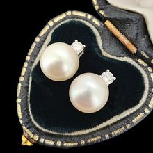 Load image into Gallery viewer, A pair of white pearl and round diamond stud earrings in white gold, in a black heart-shaped jewellery box

