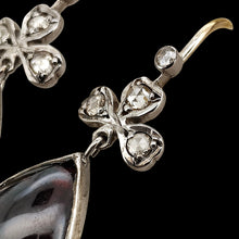 Load image into Gallery viewer, A pair of pear shaped garnet and rose cut diamond earrings in gold and silver, on a black background
