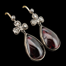 Load image into Gallery viewer, A pair of pear shaped garnet and rose cut diamond earrings in gold and silver, on a black background
