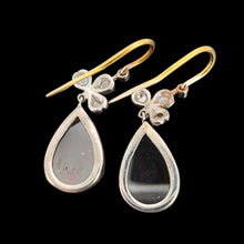 Load image into Gallery viewer, A pair of pear shaped garnet and rose cut diamond earrings in gold and silver, on a black background
