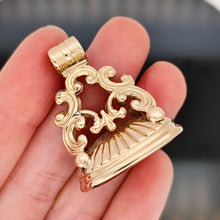 Load image into Gallery viewer, A yellow gold fob seal, on a black background, held in a hand
