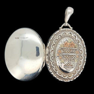 Silver locket with intricate designs on a black background