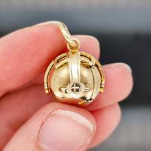 Load image into Gallery viewer, A folding masonic ball fob pendant in gold and silver, held in a hand
