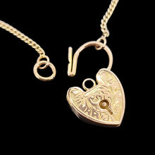 Load image into Gallery viewer, Gold heart-shaped lock pendant on a chain against a black background
