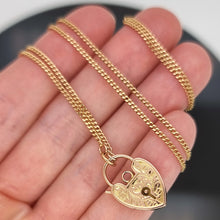 Load image into Gallery viewer, Gold chain necklace with a heart-shaped padlock clasp held in hand

