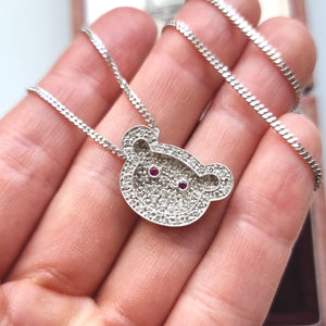 18ct White Gold Diamond and Ruby Teddy Bear Pendant with chain in hand