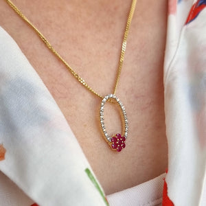 14K Yellow Gold Ruby and Diamond Cluster Pendant modelled, close-up, with a curb link chain 