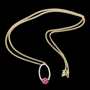 14K Yellow Gold Ruby and Diamond Cluster Pendant with curb link chain on a black background