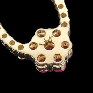 14K Yellow Gold Ruby and Diamond Cluster Pendant close-up of the 14K stamp, on a black background