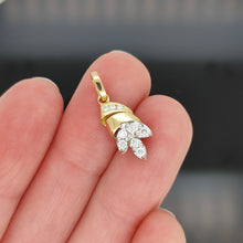 Load image into Gallery viewer, A yellow and white gold diamond set leaf shaped pendant, held in a hand

