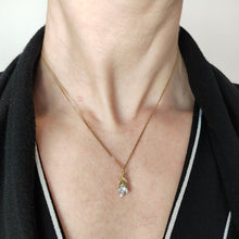 Load image into Gallery viewer, A yellow and white gold diamond set leaf shaped pendant, modelled on a gold chain by a woman
