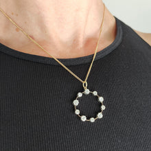 Load image into Gallery viewer, A ten stone old cut diamond open circle pendant in silver and gold, with a gold chain, modelled by a woman wearing a black top
