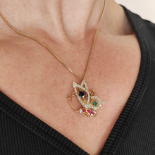 Load image into Gallery viewer, A yellow gold butterfly pendant with diamonds, rubies, a sapphire and an emerald, with a gold curb chain, modelled by a woman
