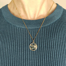 Load image into Gallery viewer, A yellow gold 30 pendant with a brilliant cut diamond, modelled with a chain by a woman wearing a blue top
