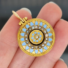 Load image into Gallery viewer, An antique pendant in yellow gold with seed pearls and light blue enamel, held in a hand
