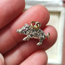 Load image into Gallery viewer, A diamond and ruby set silver pig charm with a gold jump ring, held in a hand
