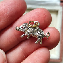Load image into Gallery viewer, A diamond and ruby set silver pig charm with a gold jump ring, held in a hand
