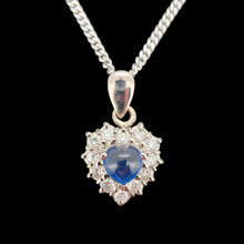 Load image into Gallery viewer, A heart shaped sapphire and diamond cluster pendant, with a curb link chain, on a black background
