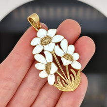Load image into Gallery viewer, A white enamelled flower pendant, held in a hand
