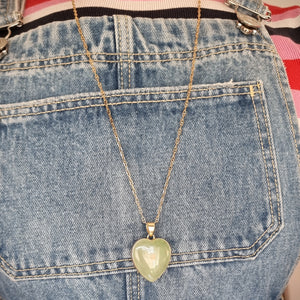 Heart-shaped pendant necklace modelled against denim
