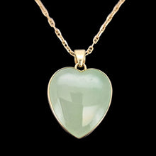 Load image into Gallery viewer, Heart-shaped jade pendant with gold frame on a black background
