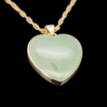 Load image into Gallery viewer, Heart-shaped green jade pendant with gold frame on a black background
