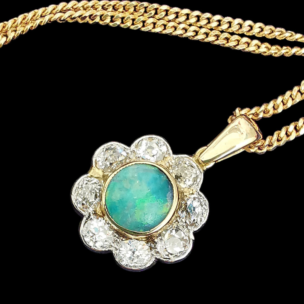 Antique 18ct Gold Opal and Diamond Cluster Pendant with a yellow gold curb link chain, on a black background