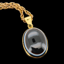 Load image into Gallery viewer, An oval banded agate pendant rubover set in yellow gold, with a yellow gold chain
