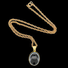 Load image into Gallery viewer, An oval banded agate pendant rubover set in yellow gold, with a yellow gold chain
