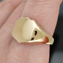 Load image into Gallery viewer, A yellow gold shield shaped signet ring, modelled on a hand
