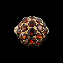 Load image into Gallery viewer, A round garnet domed cluster ring in yellow gold, against a black background
