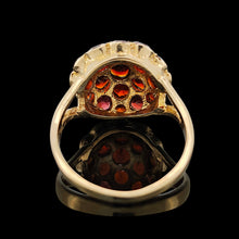 Load image into Gallery viewer, A round garnet domed cluster ring in yellow gold, against a black background
