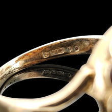 Load image into Gallery viewer, A 9ct gold London assay 1970 hallmark inside a ring, against a black background
