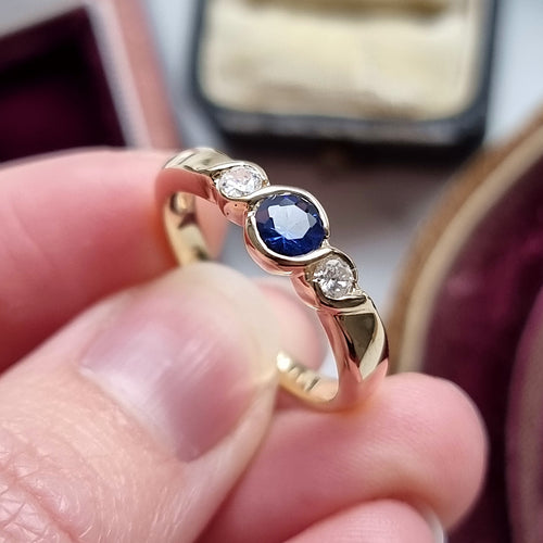 9ct Yellow Gold Sapphire and Diamond Three Stone Ring in hand