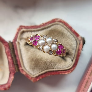 Gold ring with diamonds, pearls and rubies in an open antique jewellery box