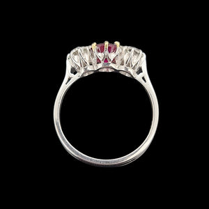 Side view of a white gold three stone ring, on a black background